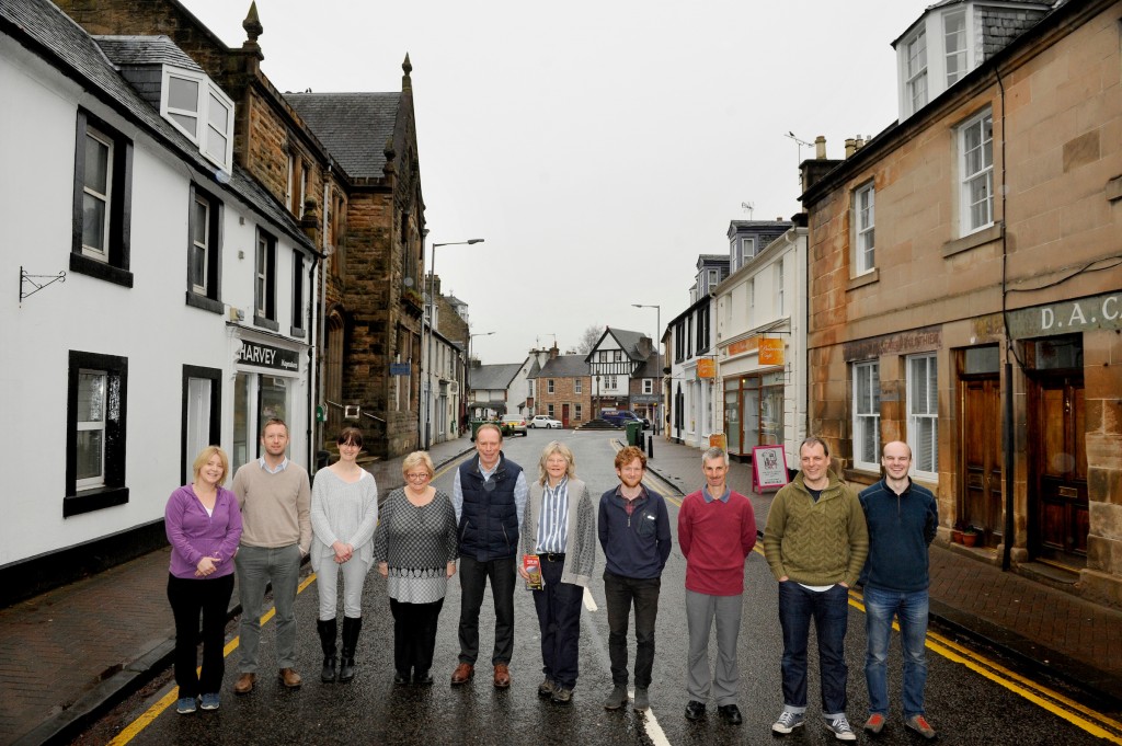 Harvey Maps, Doune, Stirlingshire, 21/11/2017: Harvey Maps staff, with founding directors Robin and Susan Harvey (centre), pictured outside their firm's offices (white building, left) on Doune's Main Street, Stirlingshire.
